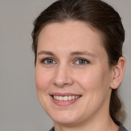 Joyful white adult female with medium  brown hair and grey eyes