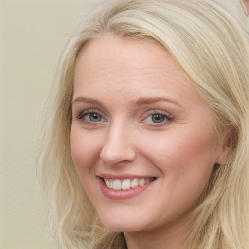 Joyful white young-adult female with long  brown hair and blue eyes