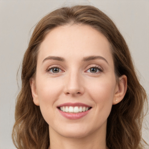 Joyful white young-adult female with long  brown hair and grey eyes