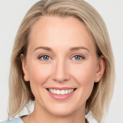 Joyful white young-adult female with medium  brown hair and blue eyes