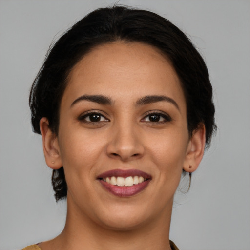 Joyful latino young-adult female with medium  brown hair and brown eyes