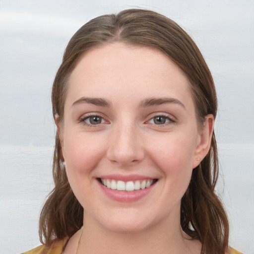 Joyful white young-adult female with medium  brown hair and blue eyes