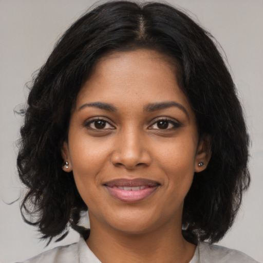 Joyful black young-adult female with medium  black hair and brown eyes