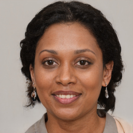 Joyful black adult female with medium  brown hair and brown eyes