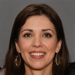 Joyful white adult female with long  brown hair and brown eyes