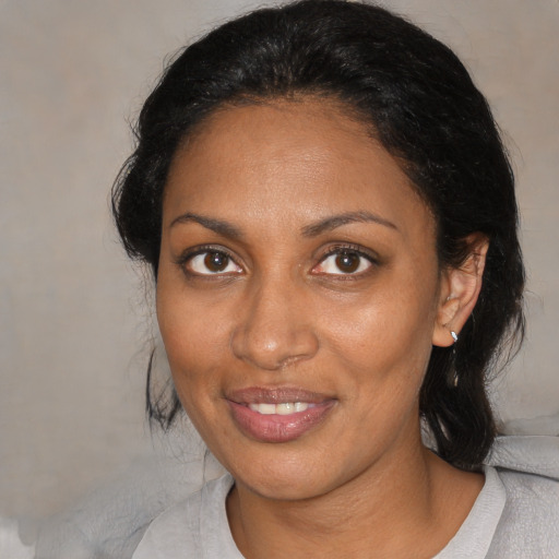 Joyful black adult female with medium  black hair and brown eyes