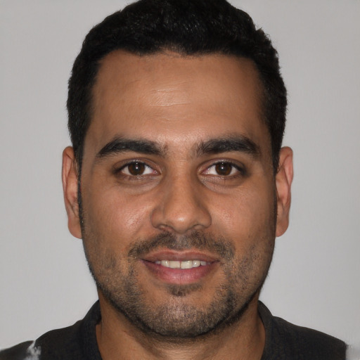 Joyful black young-adult male with short  black hair and brown eyes