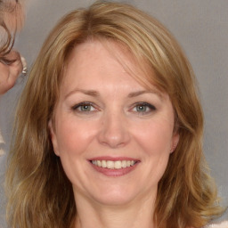 Joyful white adult female with medium  brown hair and grey eyes