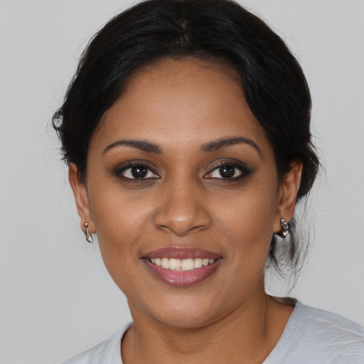 Joyful black young-adult female with medium  black hair and brown eyes