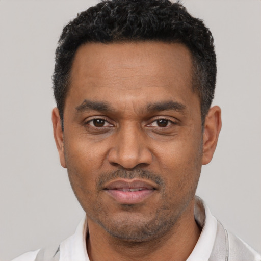 Joyful latino adult male with short  black hair and brown eyes