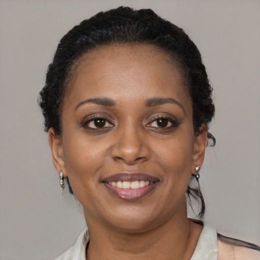 Joyful black adult female with short  black hair and brown eyes