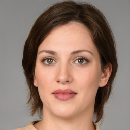 Joyful white young-adult female with medium  brown hair and green eyes