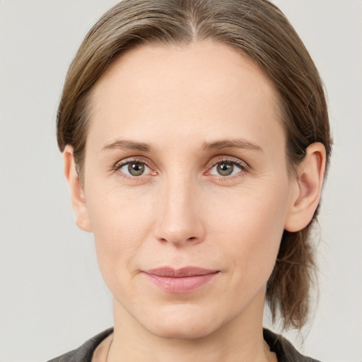 Joyful white young-adult female with medium  brown hair and grey eyes