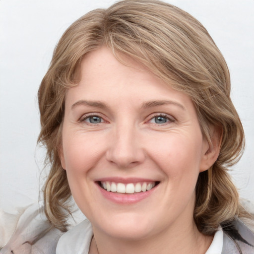 Joyful white young-adult female with medium  brown hair and blue eyes