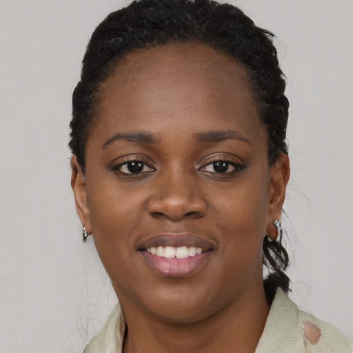 Joyful black young-adult female with short  black hair and brown eyes