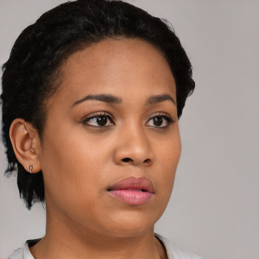 Joyful latino young-adult female with short  black hair and brown eyes