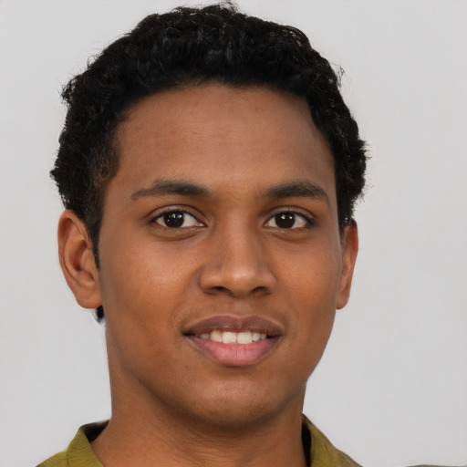 Joyful black young-adult male with short  brown hair and brown eyes
