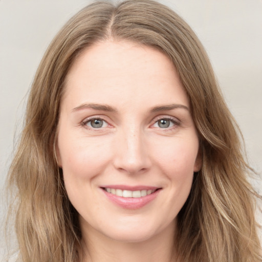 Joyful white young-adult female with long  brown hair and green eyes