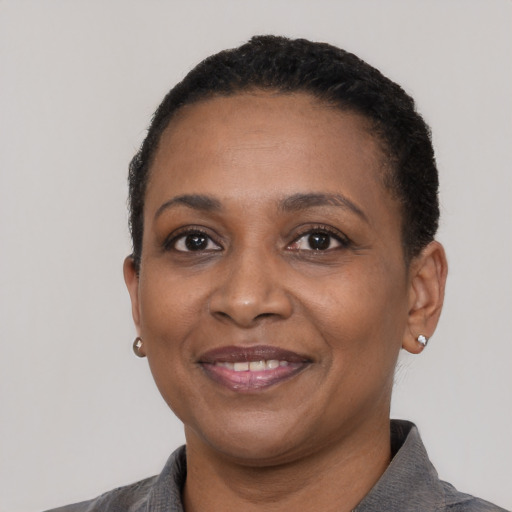 Joyful black adult female with short  black hair and brown eyes