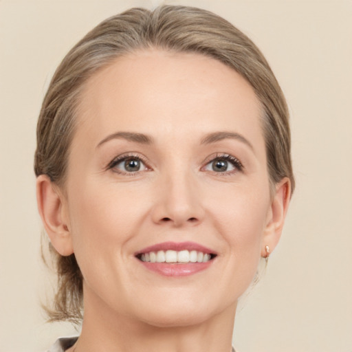 Joyful white adult female with medium  brown hair and grey eyes