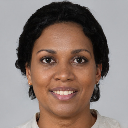 Joyful black adult female with short  black hair and brown eyes