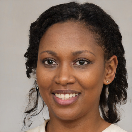 Joyful black young-adult female with medium  brown hair and brown eyes