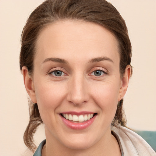 Joyful white young-adult female with medium  brown hair and grey eyes