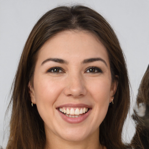 Joyful white young-adult female with long  brown hair and brown eyes