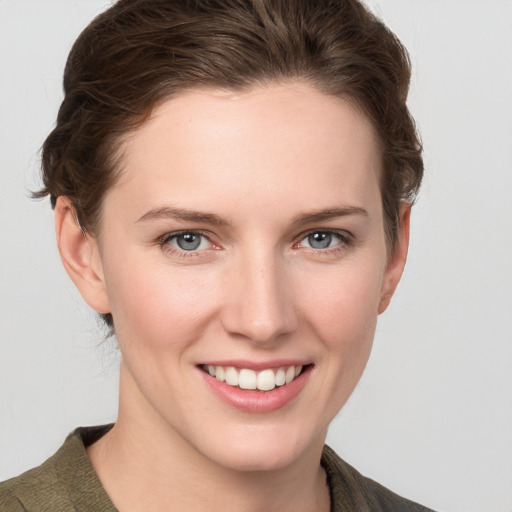 Joyful white young-adult female with short  brown hair and grey eyes