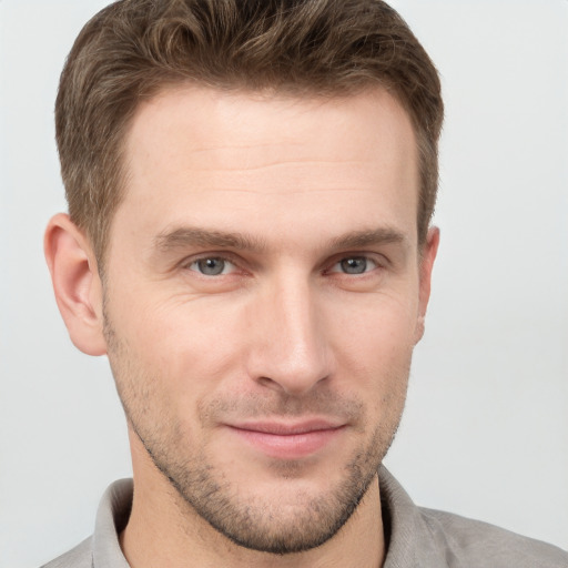 Joyful white young-adult male with short  brown hair and grey eyes