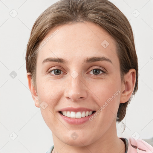 Joyful white young-adult female with short  brown hair and grey eyes