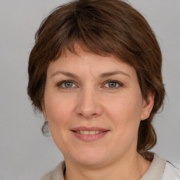 Joyful white adult female with medium  brown hair and grey eyes