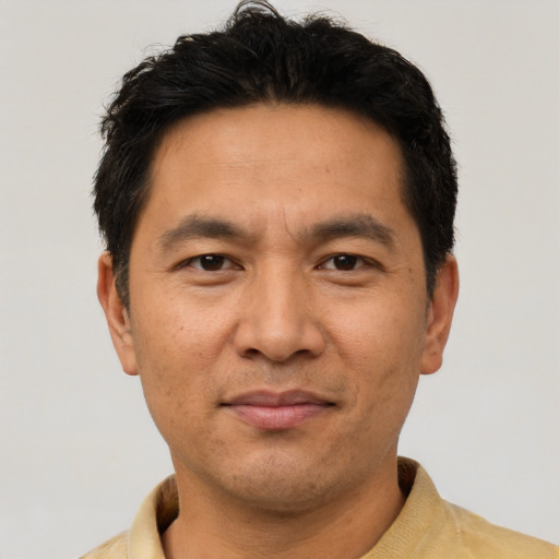 Joyful asian adult male with short  black hair and brown eyes