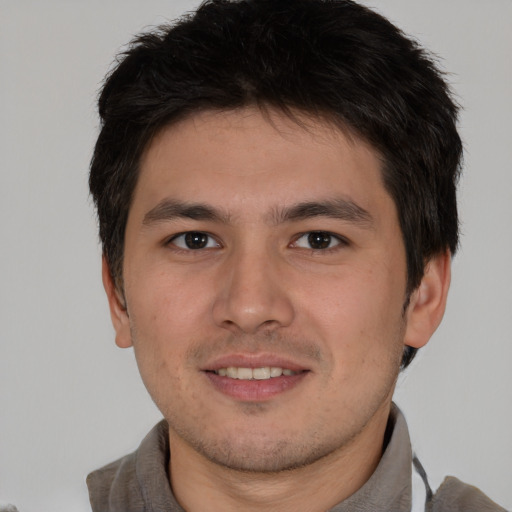 Joyful asian young-adult male with short  brown hair and brown eyes