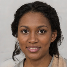 Joyful black young-adult female with long  brown hair and brown eyes