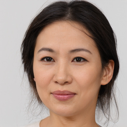 Joyful asian adult female with medium  brown hair and brown eyes