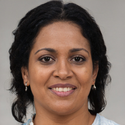 Joyful black adult female with medium  brown hair and brown eyes