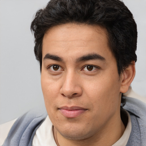 Joyful latino young-adult male with short  brown hair and brown eyes
