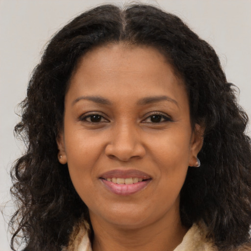 Joyful black adult female with long  brown hair and brown eyes