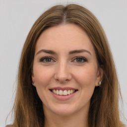 Joyful white young-adult female with long  brown hair and green eyes