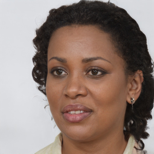 Joyful black young-adult female with long  brown hair and brown eyes