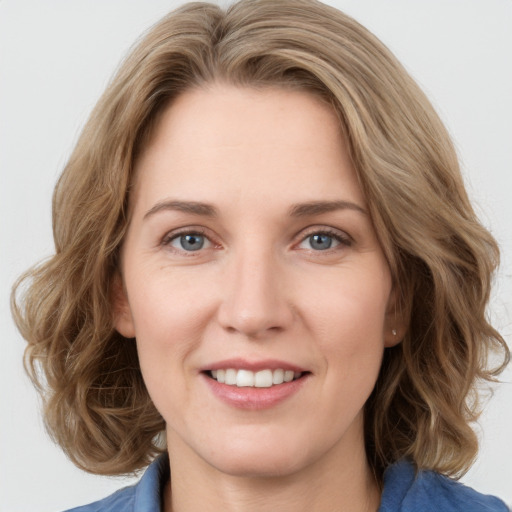 Joyful white young-adult female with medium  brown hair and blue eyes