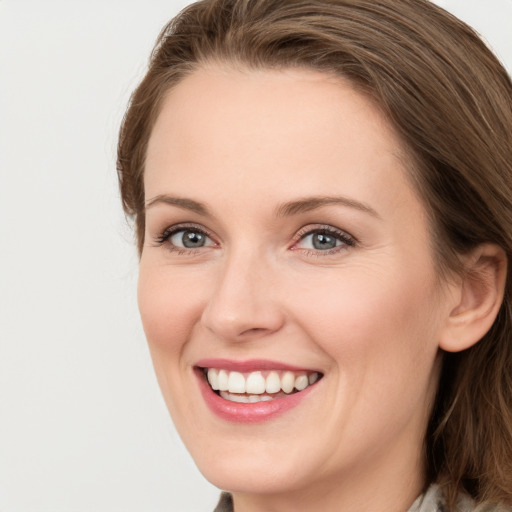 Joyful white young-adult female with long  brown hair and grey eyes