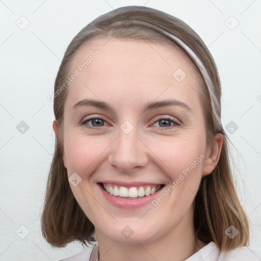 Joyful white young-adult female with long  brown hair and blue eyes