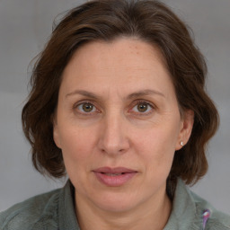 Joyful white adult female with medium  brown hair and blue eyes