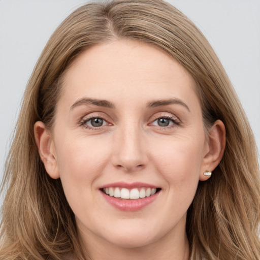 Joyful white young-adult female with long  brown hair and grey eyes