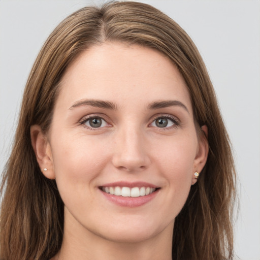 Joyful white young-adult female with long  brown hair and grey eyes