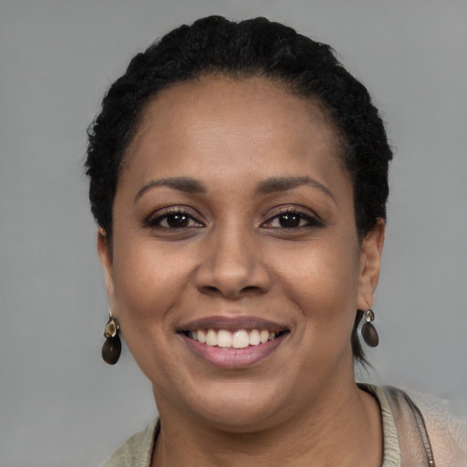 Joyful black young-adult female with short  black hair and brown eyes