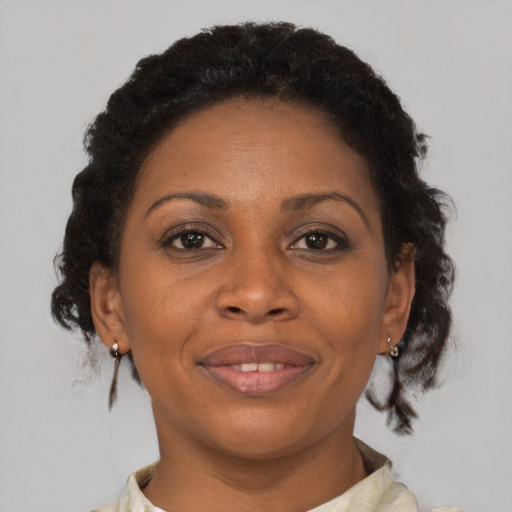 Joyful black adult female with medium  brown hair and brown eyes