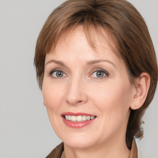 Joyful white adult female with medium  brown hair and grey eyes